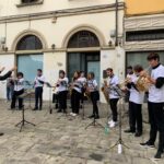 Un gruppo di studenti suonano seguendo il maestro d'orchestra